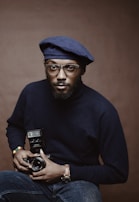 selective focus photo of man holding camera with flash