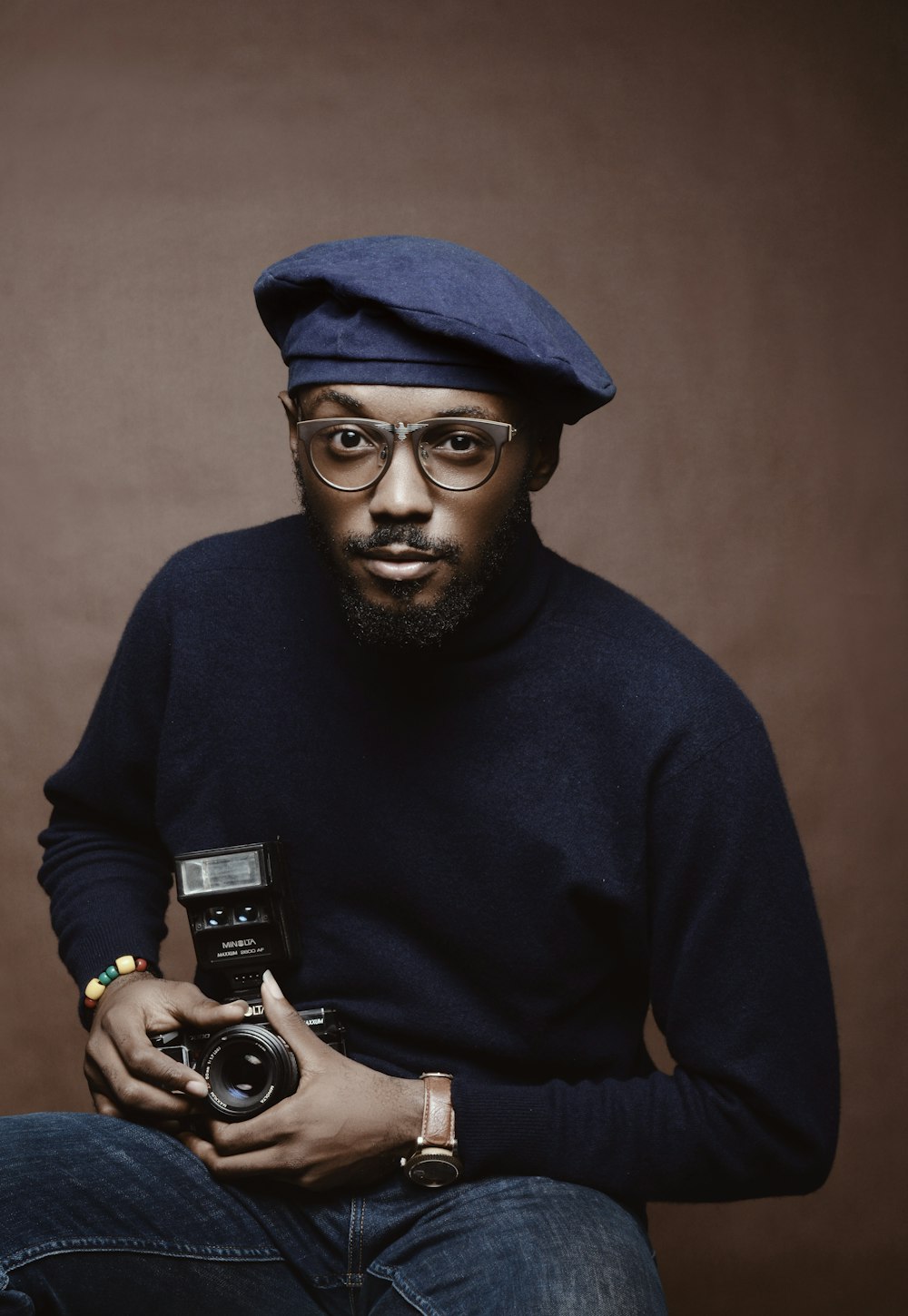 selective focus photo of man holding camera with flash