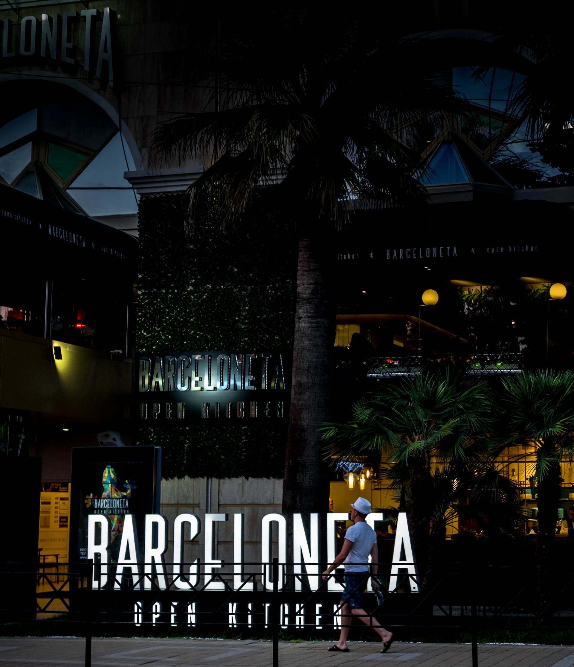 A lively tapas bar terrace at sunset, with locals enjoying plates of jamón and glasses of chilled sangria under warm string lights.