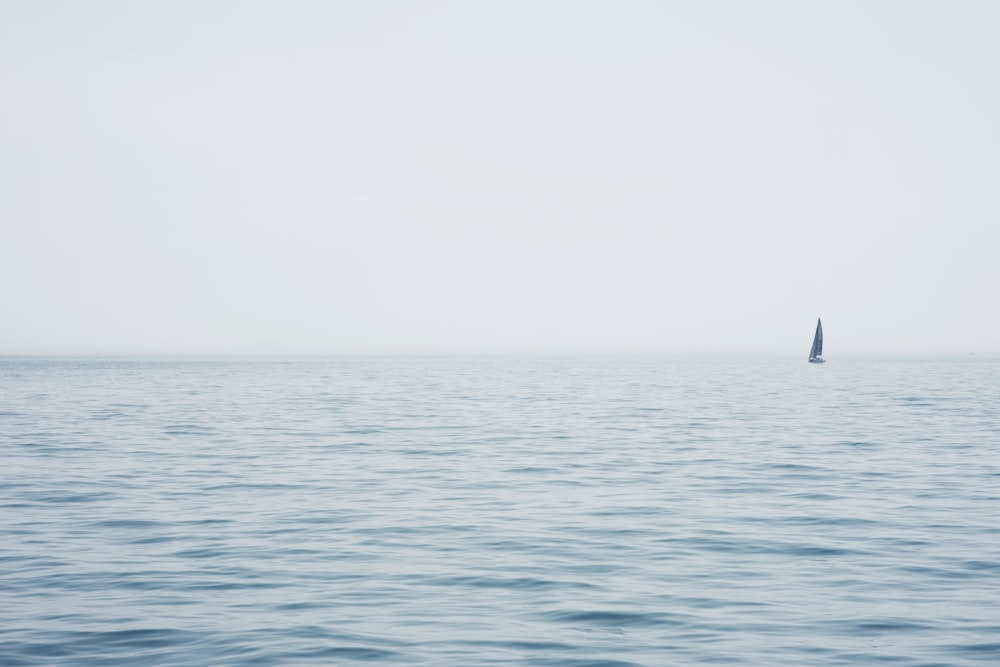 Barca a vela blu che naviga in mare aperto