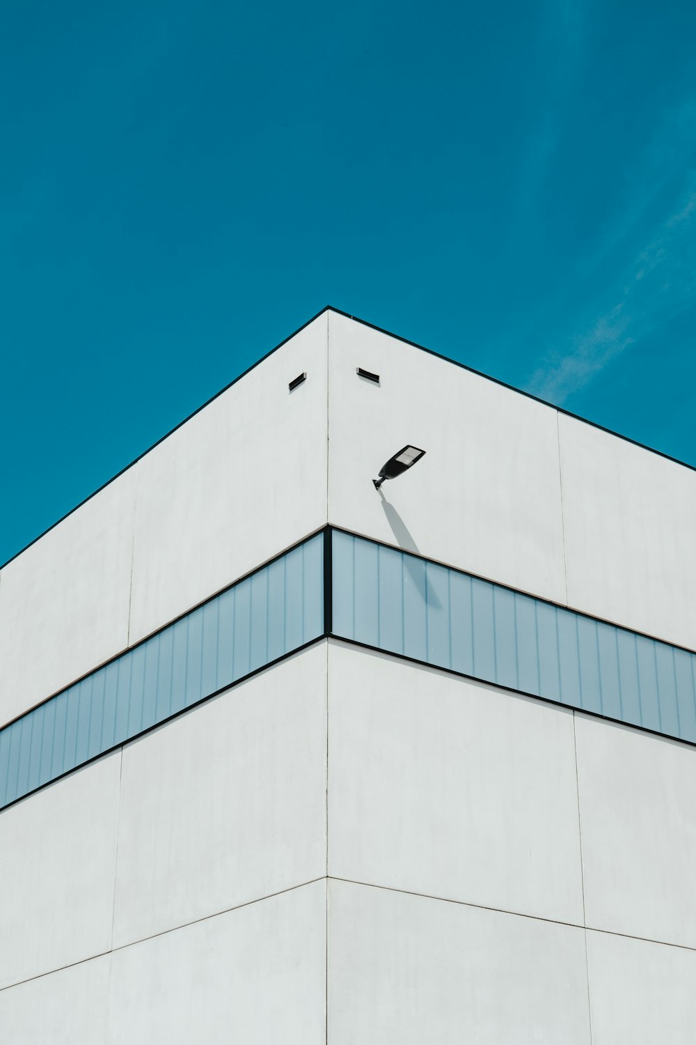 Weißes und grünes Betongebäude unter blauem Himmel