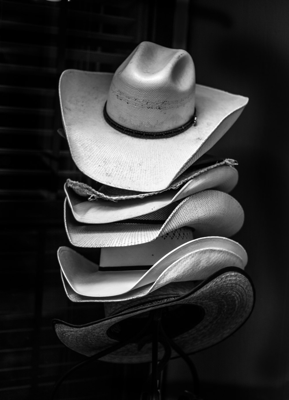 fotografia in scala di grigi di cappelli da cowboy impilati