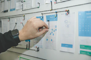 person working on blue and white paper on board