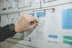 person working on blue and white paper on board