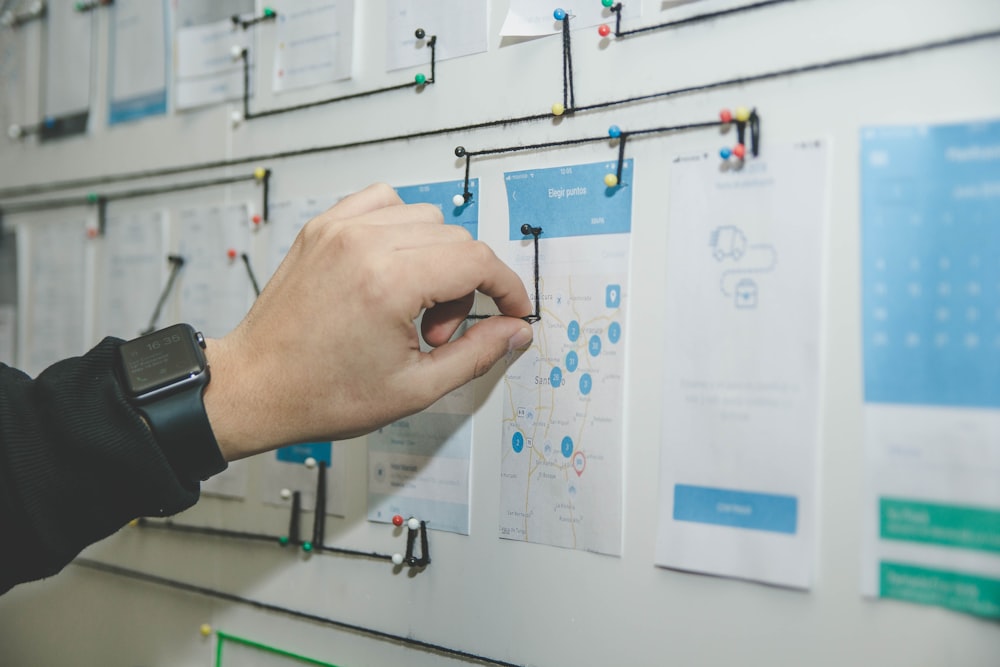 person working on blue and white paper on board