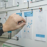 person working on blue and white paper on board