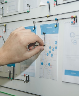 person working on blue and white paper on board