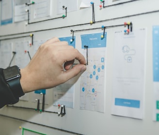 person working on blue and white paper on board