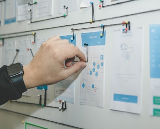 person working on blue and white paper on board