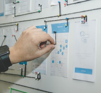 person working on blue and white paper on board