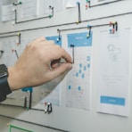 person working on blue and white paper on board