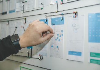 person working on blue and white paper on board