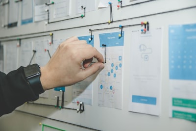 person working on blue and white paper on board design teams background