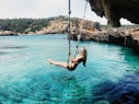 woman on hammock above body of water