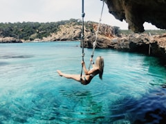 woman on hammock above body of water