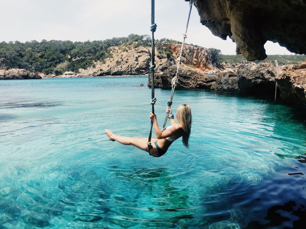 woman on hammock above body of water