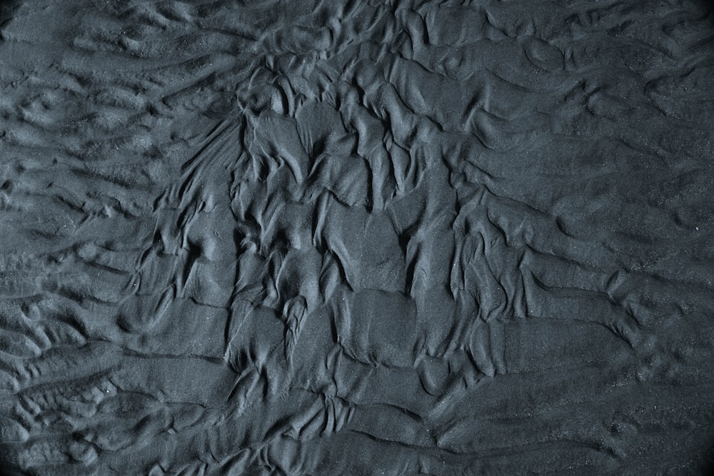 a black and white photo of sand and water