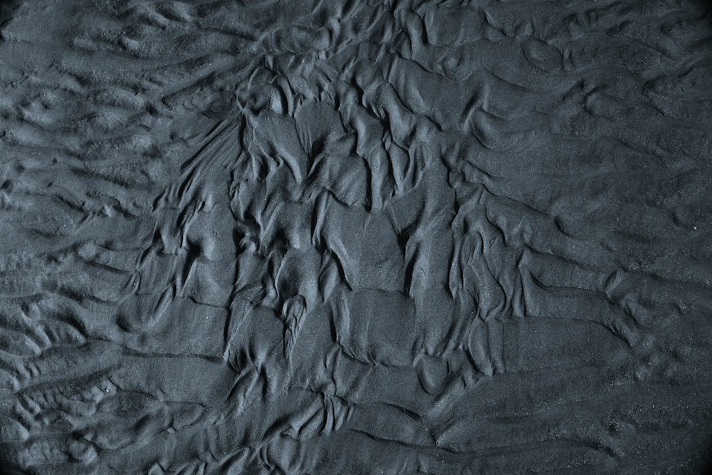 Una foto in bianco e nero di sabbia e acqua