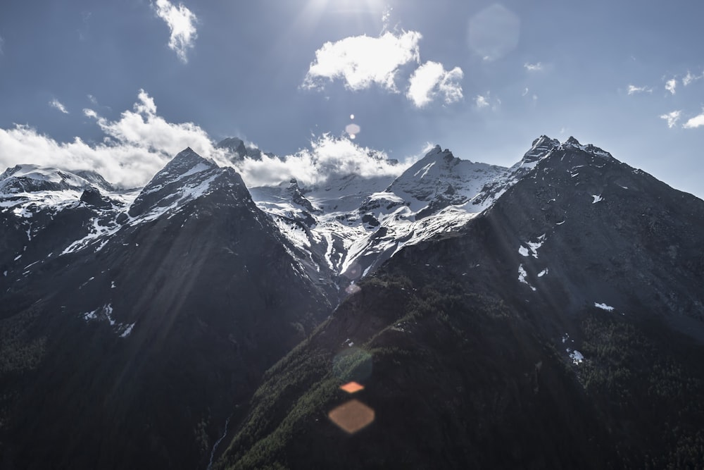 mountains under white clouds and blue sky at daytime