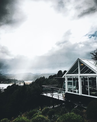 Modern container home seamlessly integrated into a lush New Zealand garden with mountains in the background.