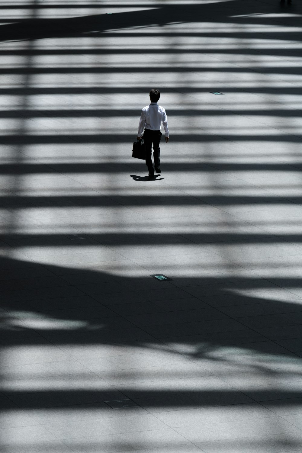 homem segurando saco do portátil andando na rua