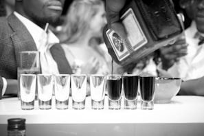 A tasteful shot of a corporate meeting with executives discussing distribution plans over branded liquor samples.