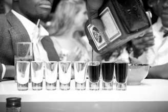 A tasteful shot of a corporate meeting with executives discussing distribution plans over branded liquor samples.