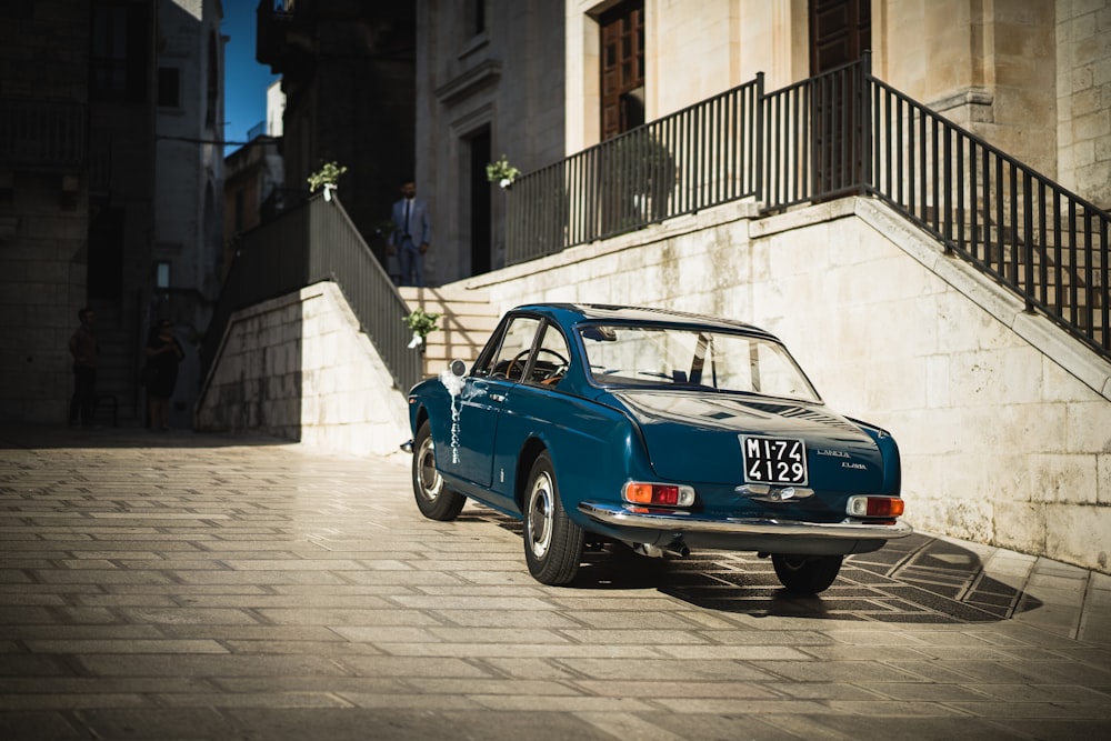 blue coupe parked beside building