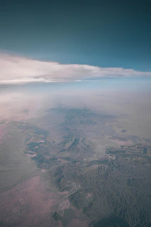 A panoramic shot of a drone mapping a large farm area with mountains in the background