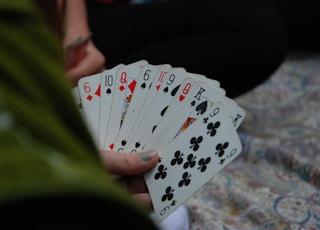 person holding fan of playing cards