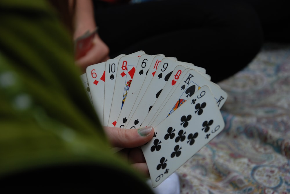 person holding fan of playing cards
