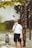 man smoking cigarette walking beside tree