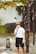 man smoking cigarette walking beside tree