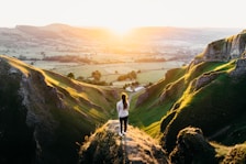 photo of woman standing on cliff