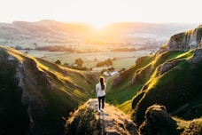 photo of woman standing on cliff