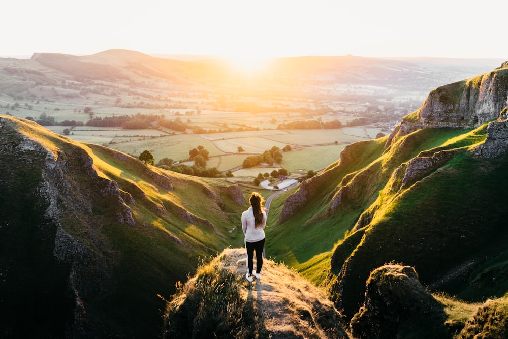 photo of woman standing on cliff