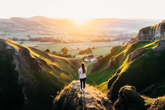 photo of woman standing on cliff in Winnats Pass United Kingdom