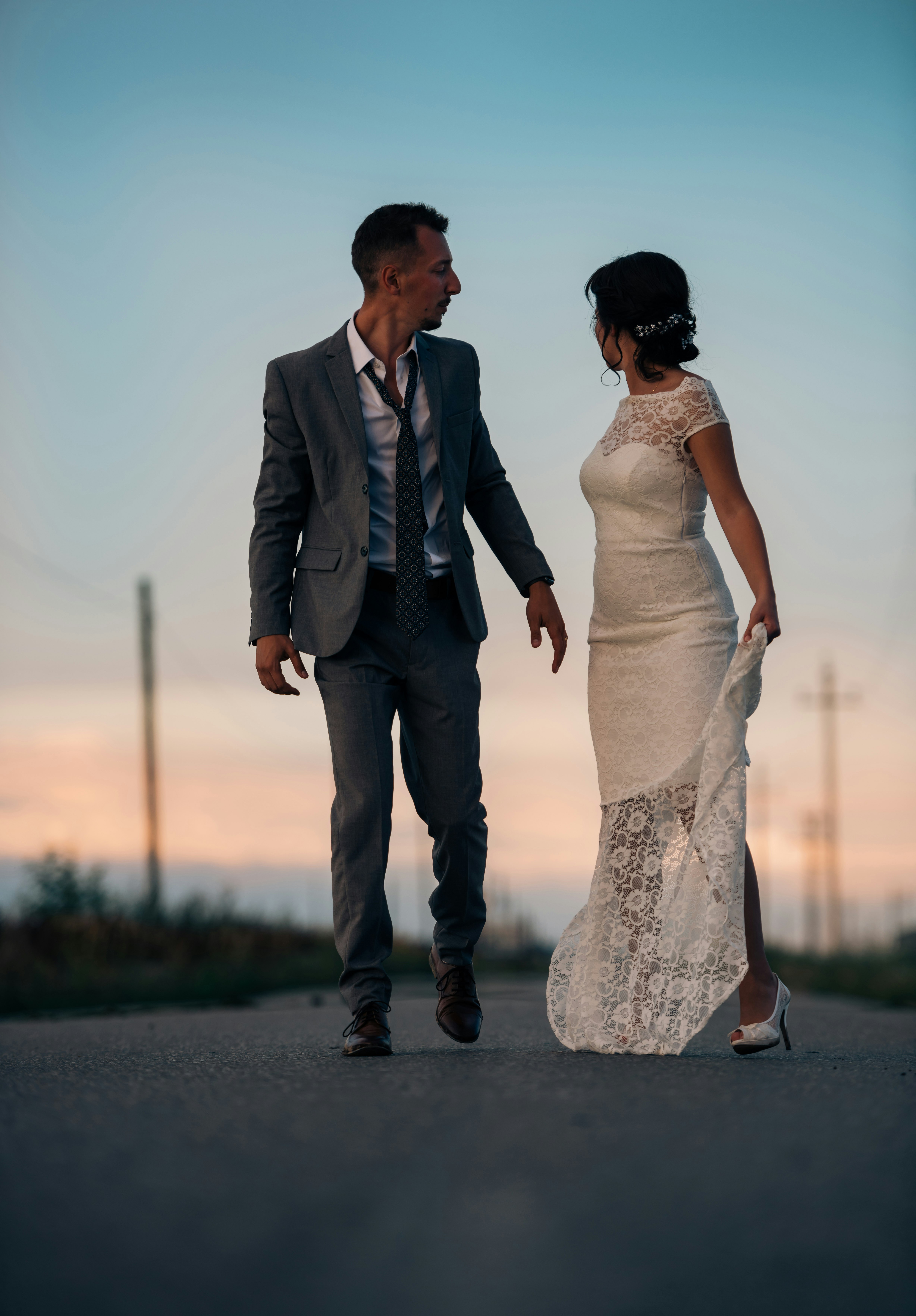 woman in wedding dress beside man in gray suit jacket