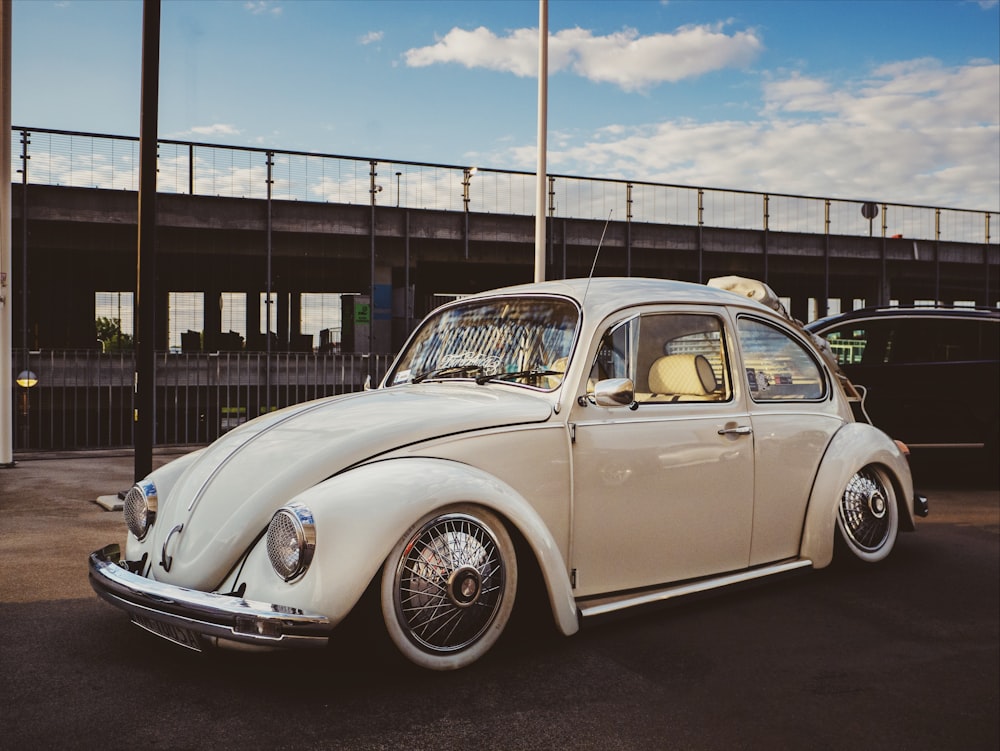 white Volkswagen Beetle hatchback parked near post