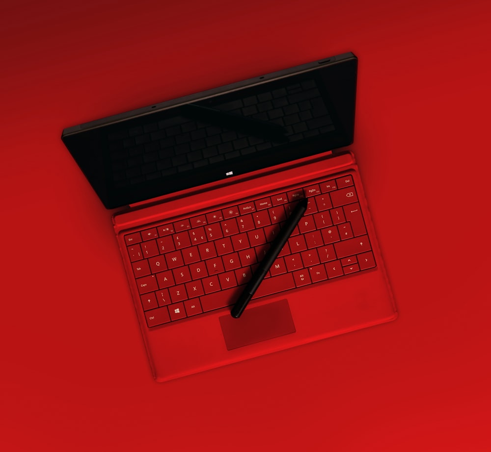 black pen on red laptop computer