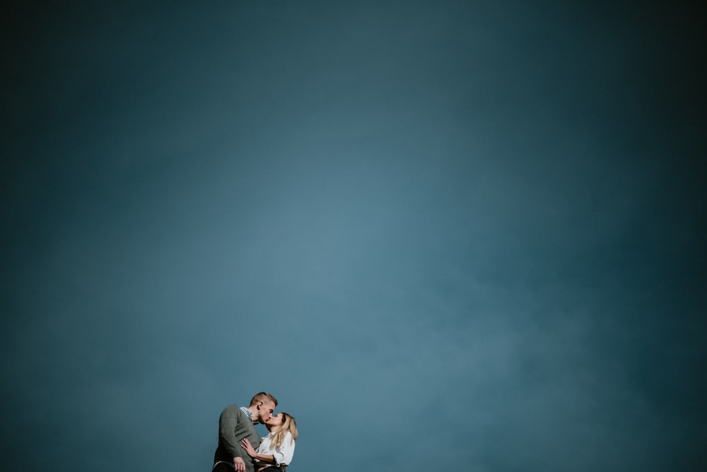 青空の下でキスをするカップルのローアングル写真