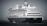 A large cruise ship is sailing on open water, featuring multiple decks and lifeboats along the side. The ship is primarily black and white with distinctive design elements and a name visible at the front.