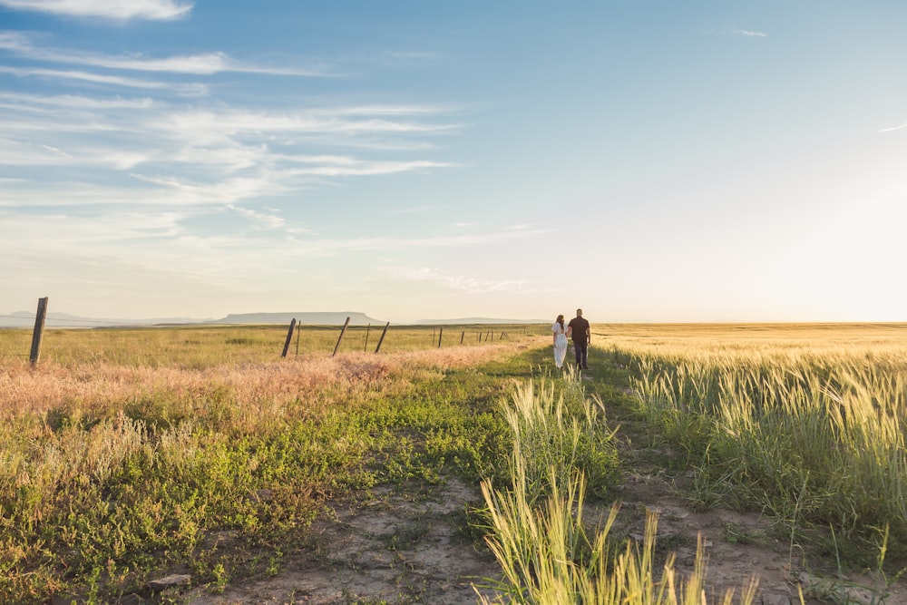 a man and a woman walking down a dirt road