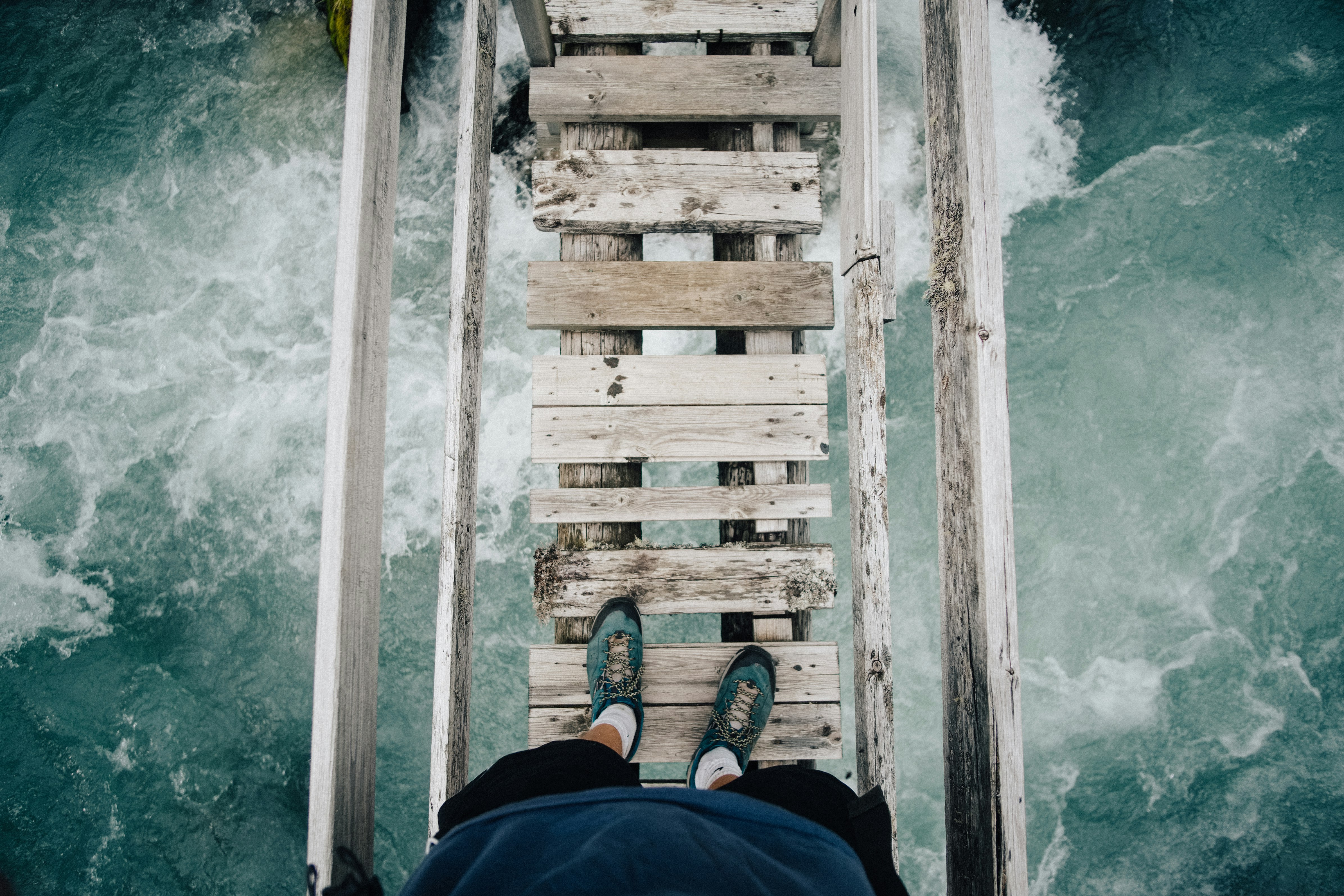 person standing on wooden bridge