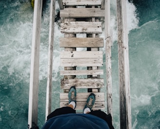 person standing on wooden bridge