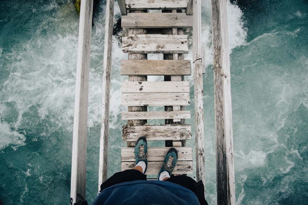 Person, die auf Holzbrücke steht