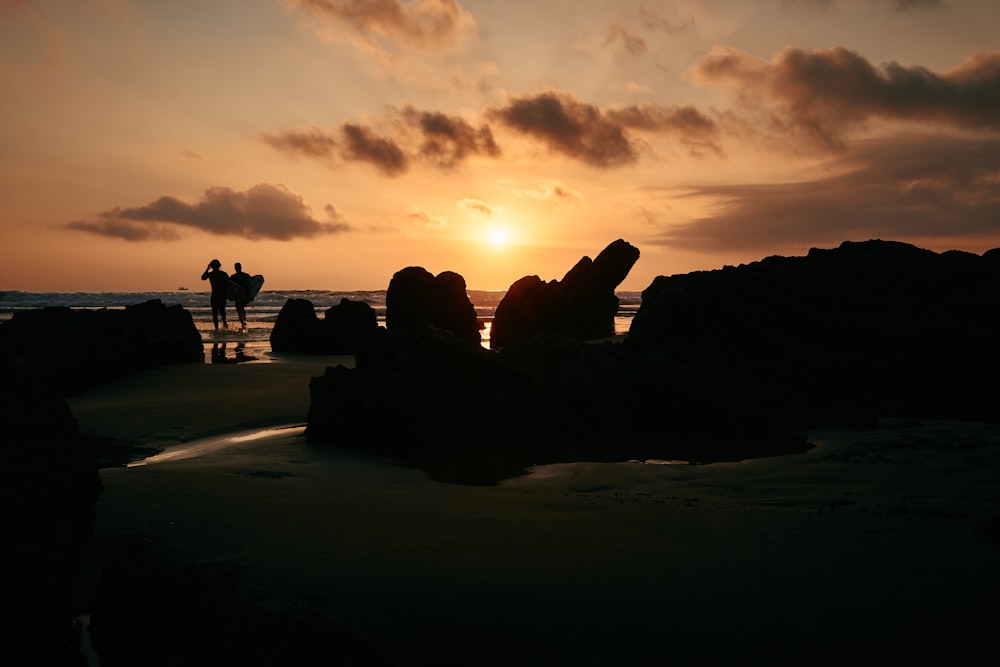 silhouette of rock formation beside shoreline