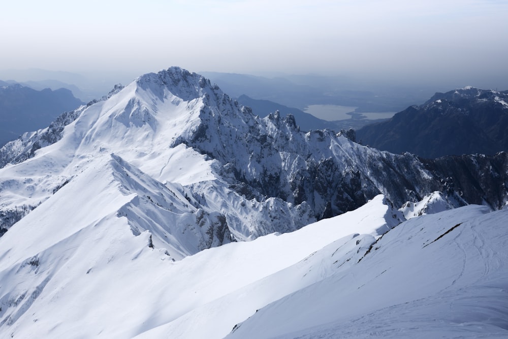 昼間の曇り空の下、雪に覆われた山