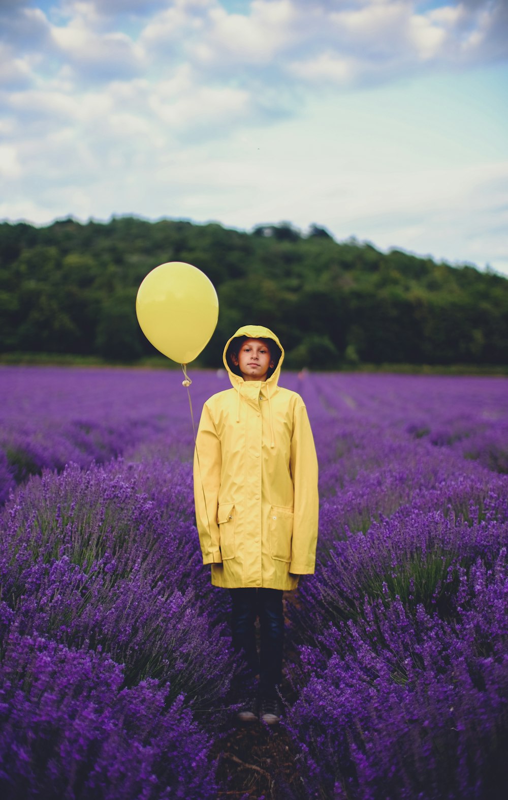 woman in yellow dress shirt near purple flower field