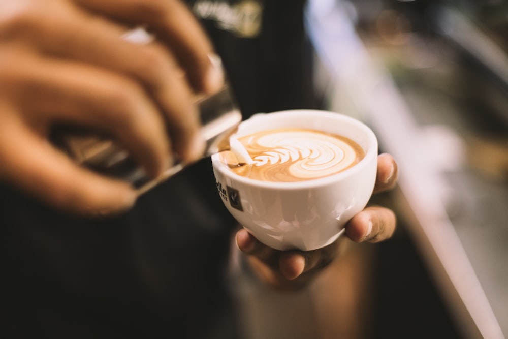 white ceramic coffee cup with latte art